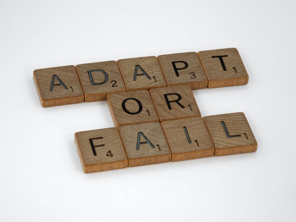 Piezas de Scrabble deletreando "Adaptarse o fracasar"